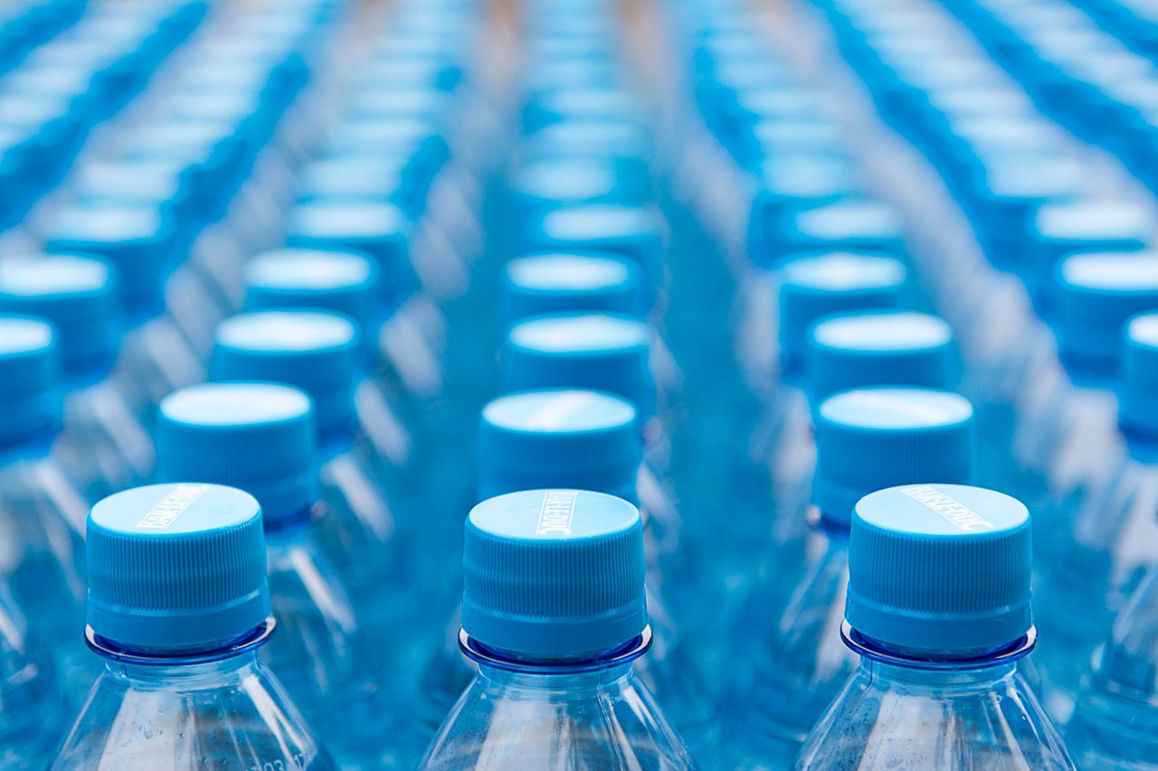 services-02 Array of blue plastic water bottles with caps arranged in a pattern. Ideal for recycling and packaging themes.